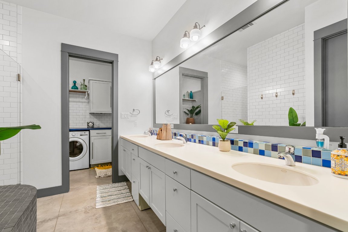 332 Rugged Earth Drive, Unit 1 Austin, TX 78737 - Photo 19 of 32 a en suite bathroom with a double vanity sink a mirror and shower