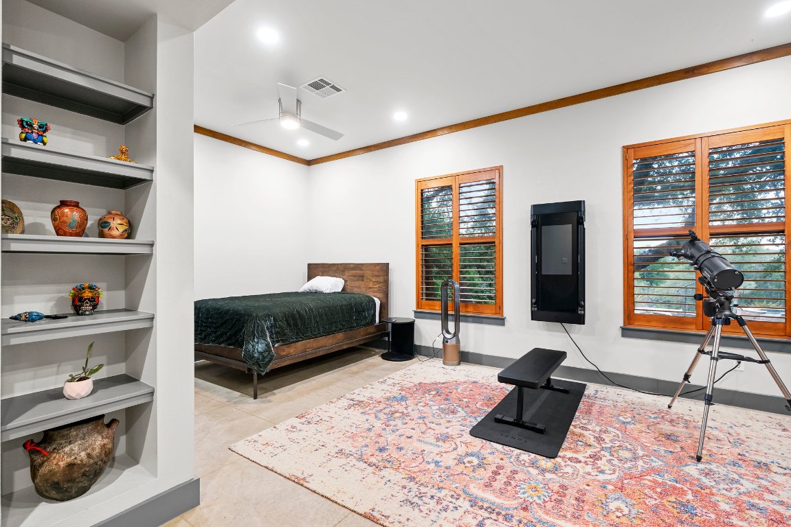332 Rugged Earth Drive, Unit 1 Austin, TX 78737 - Photo 21 of 32 a bedroom with furniture and a book shelf