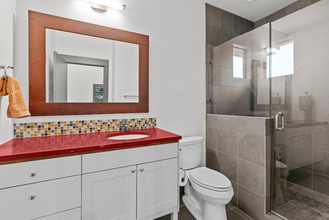 332 Rugged Earth Drive, Unit 1 Austin, TX 78737 - Photo 25 of 32 a bathroom with a toilet sink and mirror