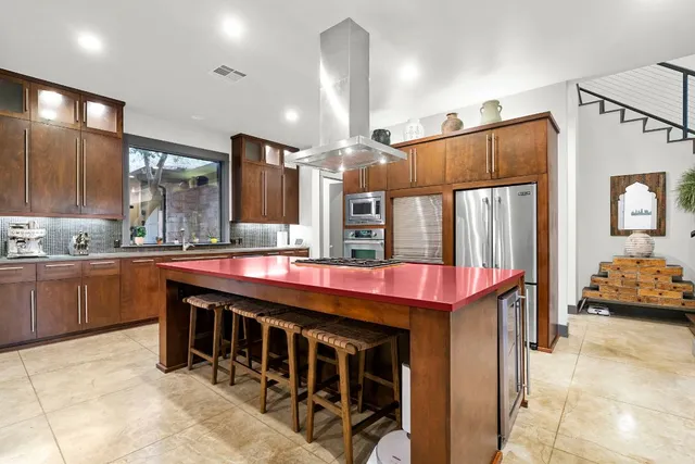 a kitchen with kitchen island granite countertop a stove and a sink
