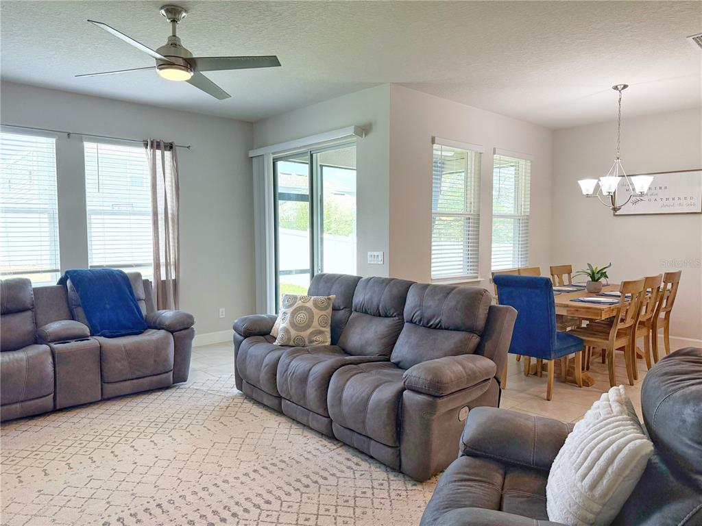 3181 Hill Point Street Minneola, FL 34715 - Photo 13 of 52 a living room with furniture a ceiling fan and a window