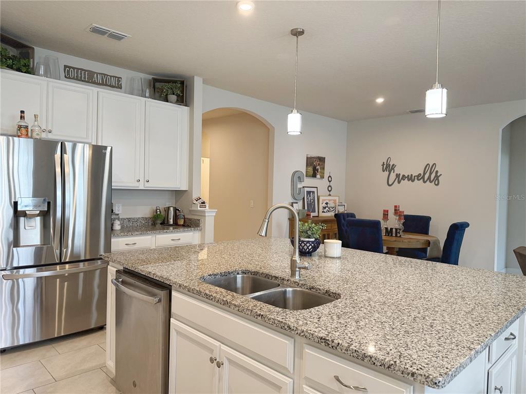 3181 Hill Point Street Minneola, FL 34715 - Photo 15 of 52 a kitchen with stainless steel appliances granite countertop a sink refrigerator and microwave