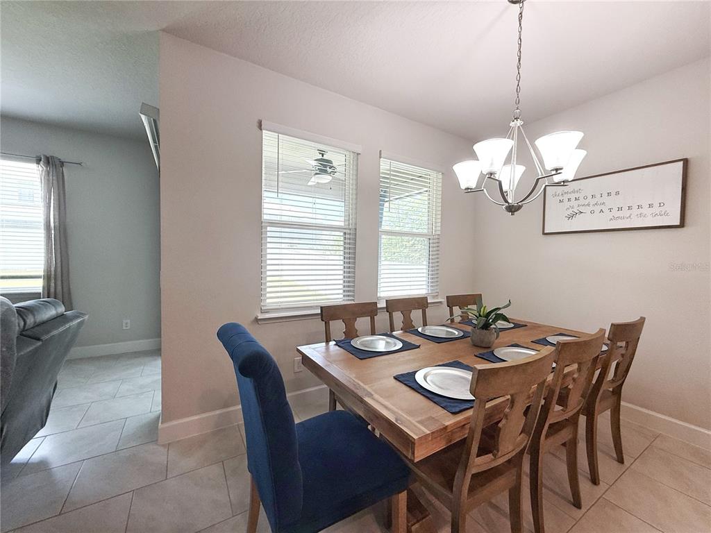 3181 Hill Point Street Minneola, FL 34715 - Photo 19 of 52 a view of a dining room and a table and chairs