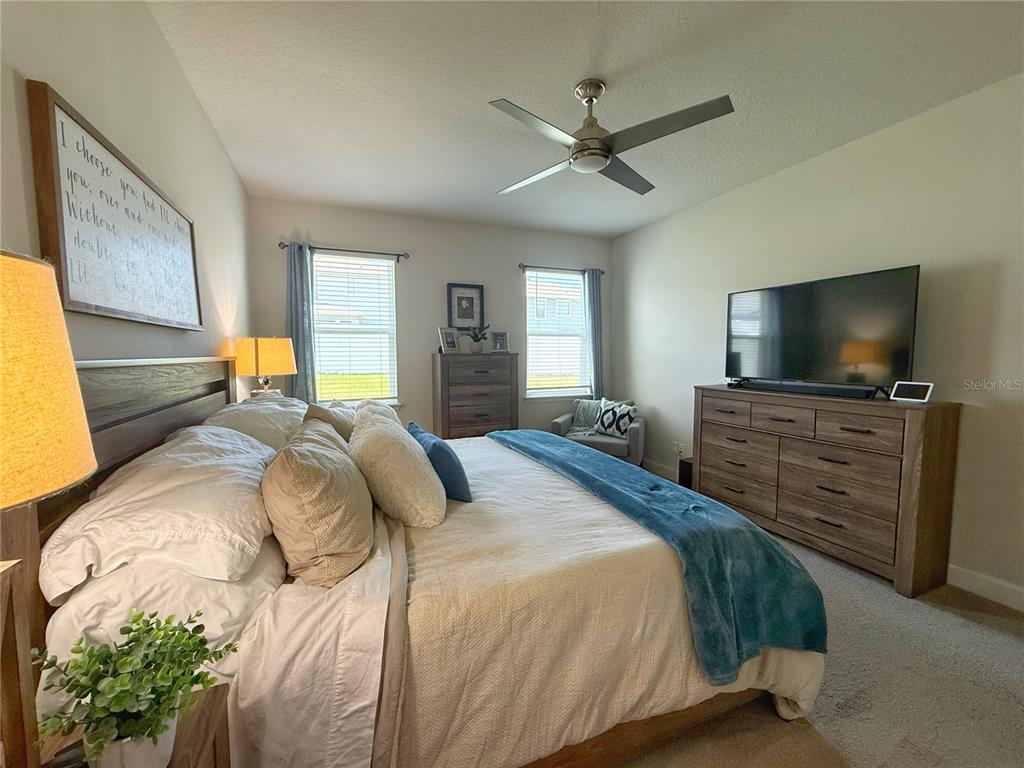 3181 Hill Point Street Minneola, FL 34715 - Photo 21 of 52 a bedroom with a bed and a flat screen tv