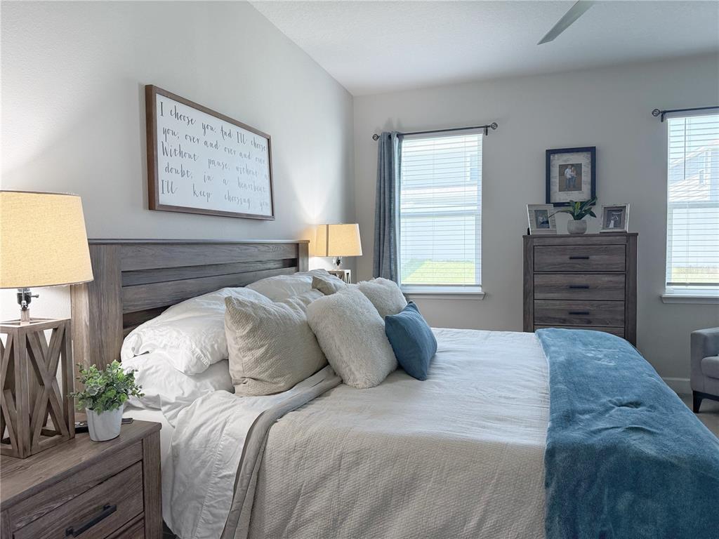 3181 Hill Point Street Minneola, FL 34715 - Photo 22 of 52 a bedroom with a bed and a dresser