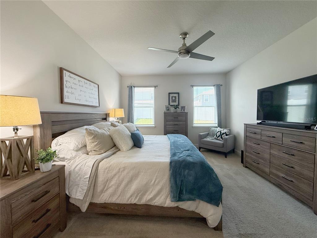 3181 Hill Point Street Minneola, FL 34715 - Photo 23 of 52 a bedroom with a bed and a flat screen tv