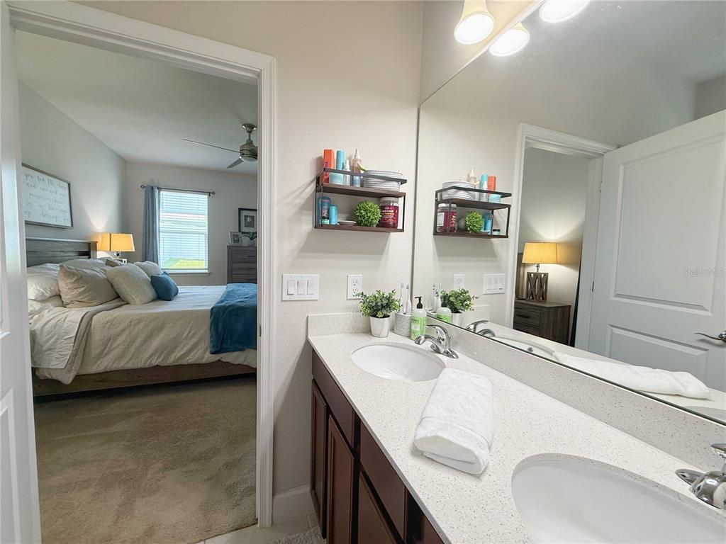 3181 Hill Point Street Minneola, FL 34715 - Photo 24 of 52 a en suite bathroom with a double vanity sink and mirror
