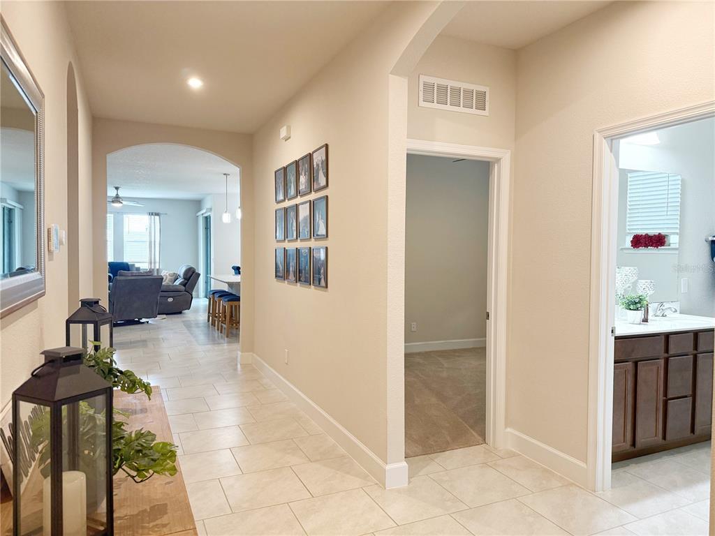 3181 Hill Point Street Minneola, FL 34715 - Photo 29 of 52 a view of a hallway with dining area and chandelier