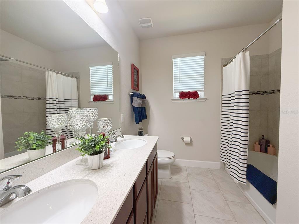 3181 Hill Point Street Minneola, FL 34715 - Photo 33 of 52 a bathroom with a granite countertop sink a toilet and shower