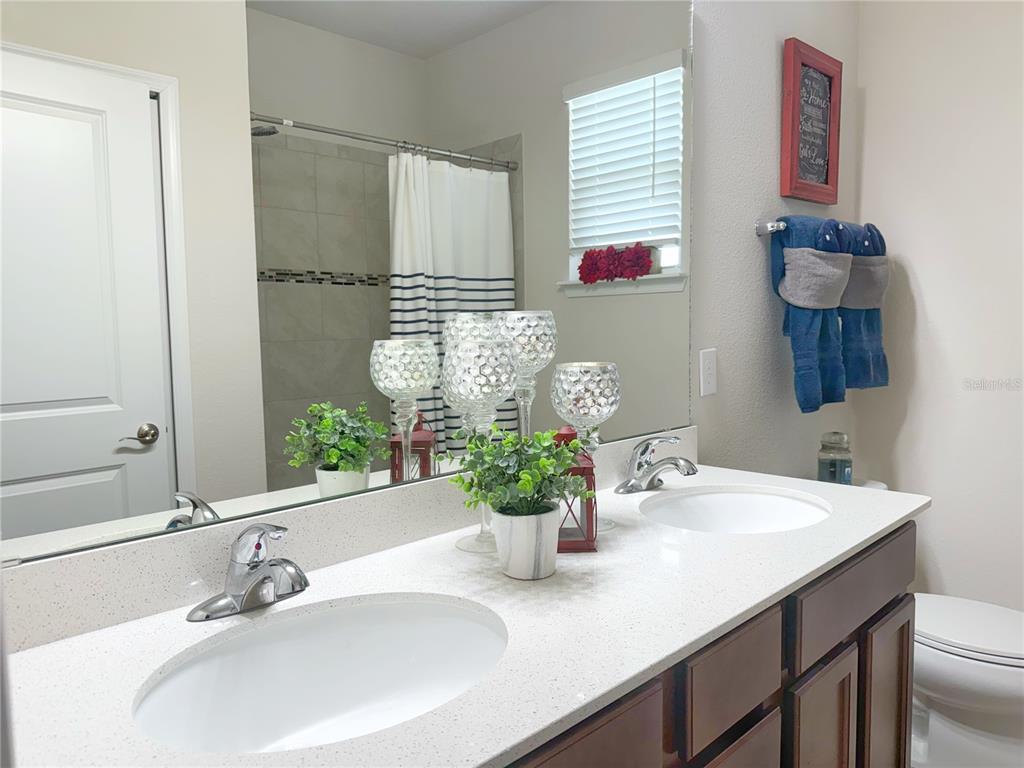 3181 Hill Point Street Minneola, FL 34715 - Photo 34 of 52 a bathroom with a sink a vanity and a mirror