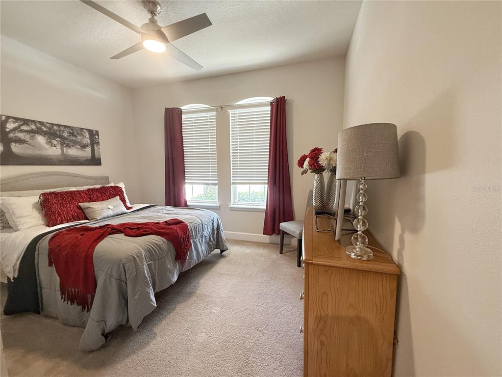 3181 Hill Point Street Minneola, FL 34715 - Photo 35 of 52 a bed room with a bed and a chair