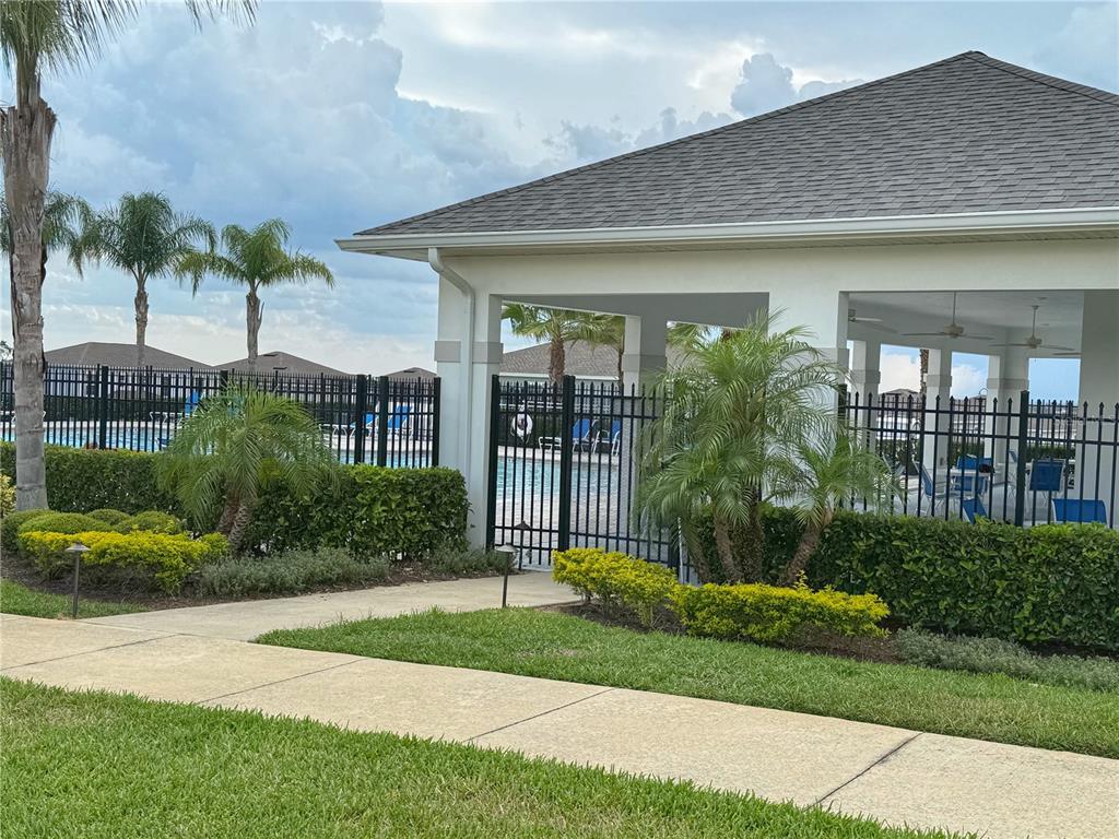 3181 Hill Point Street Minneola, FL 34715 - Photo 48 of 52 a front view of a house with a yard and potted plants