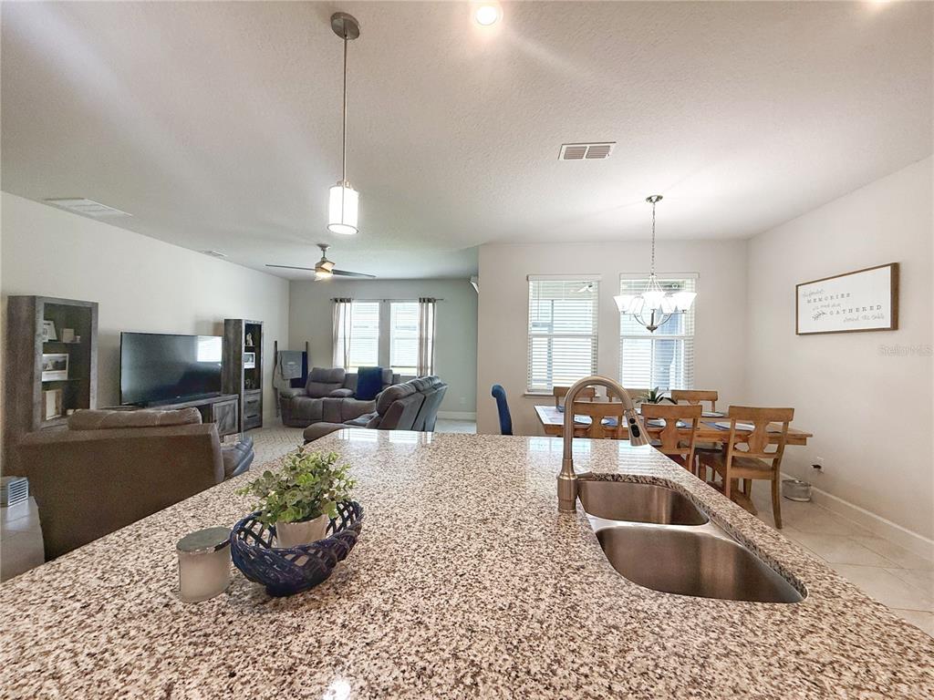 3181 Hill Point Street Minneola, FL 34715 - Photo 6 of 52 a kitchen with a stove a sink and living room view