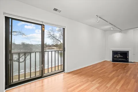 a view of an empty room with a window and a fireplace