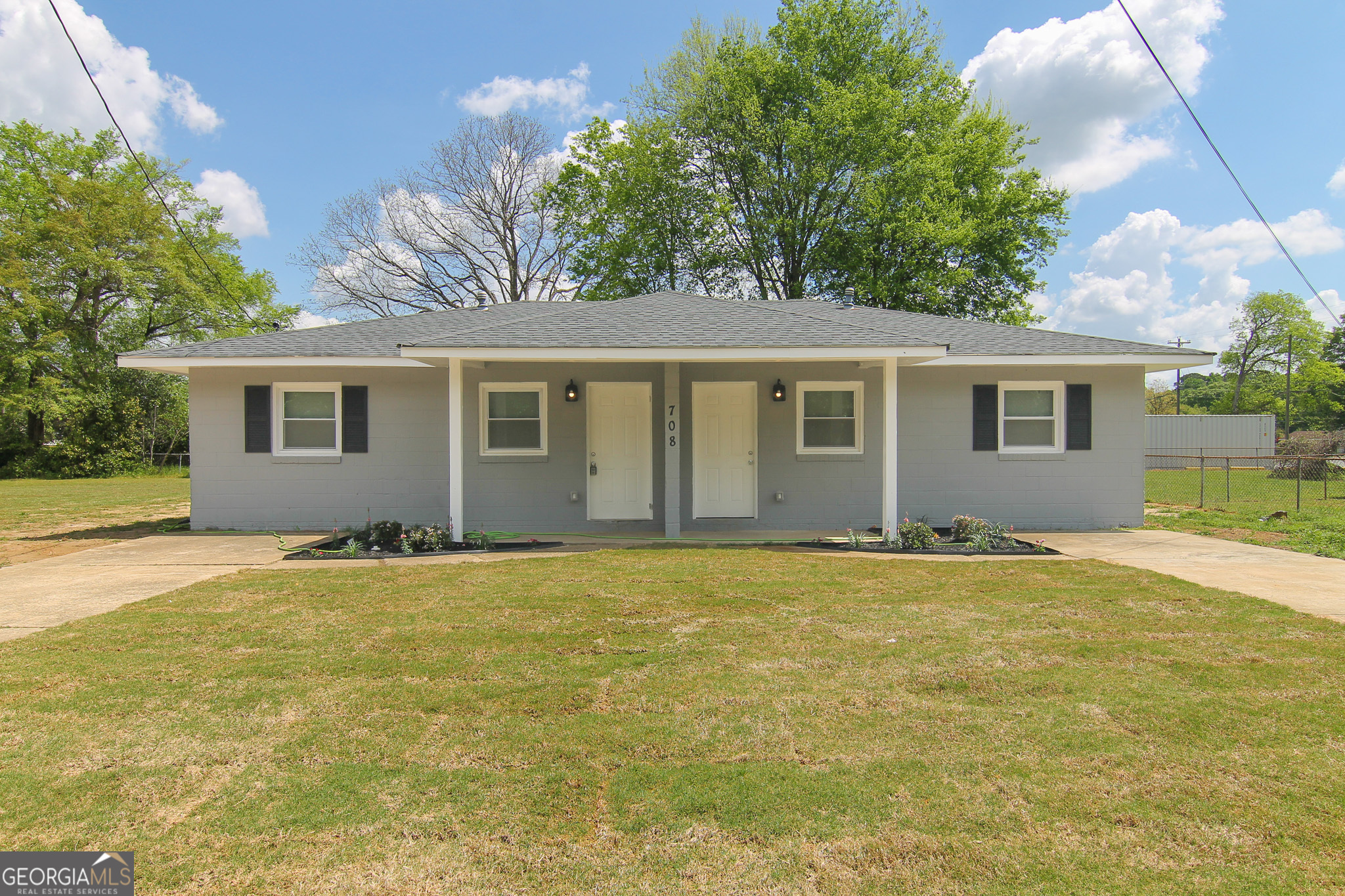 a view of a house with a backyard and a tree