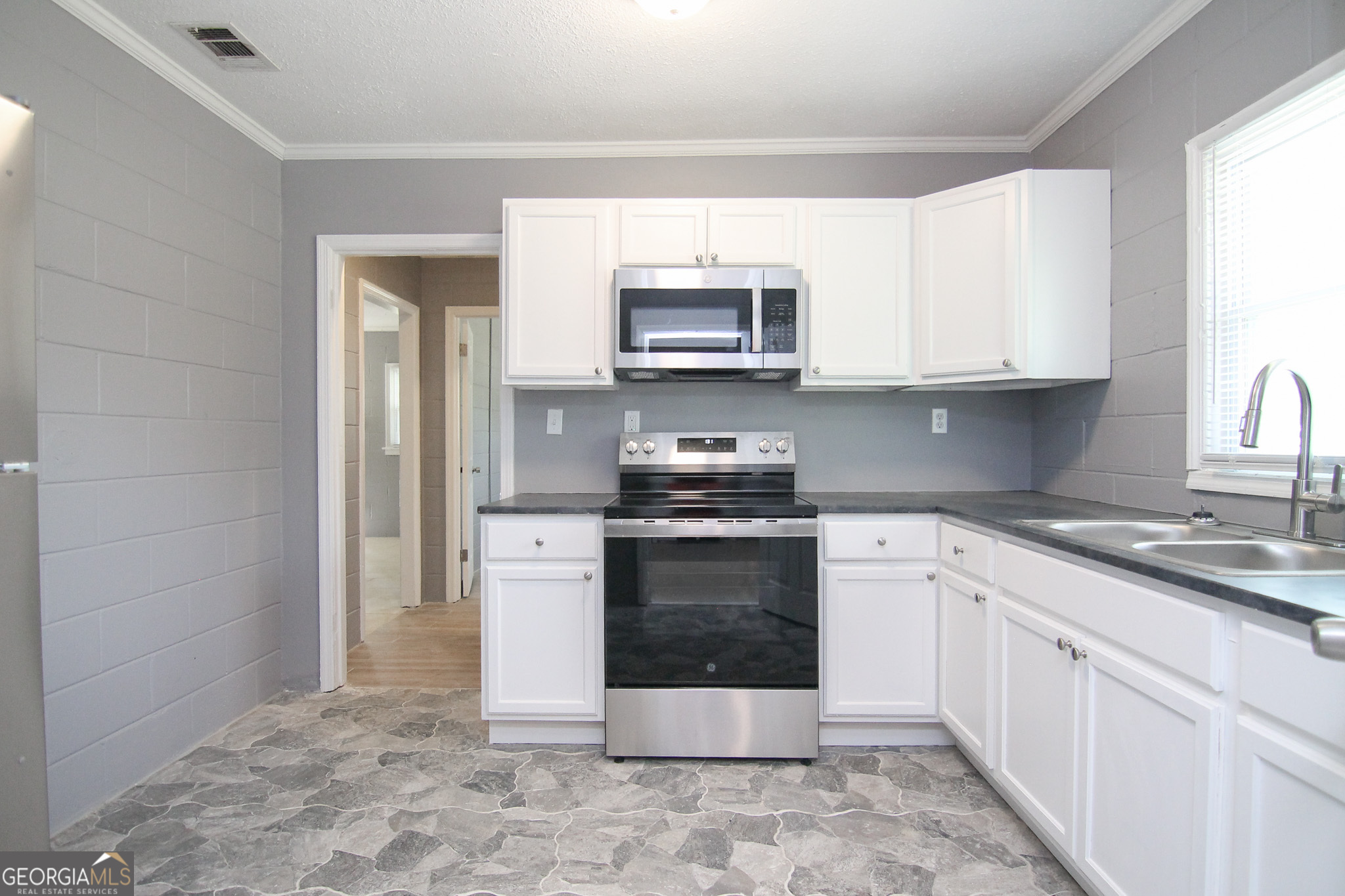 708 South 3rd Street Warner Robins, GA 31088 - Photo 11 of 29 a kitchen with stainless steel appliances granite countertop a stove a sink and a microwave