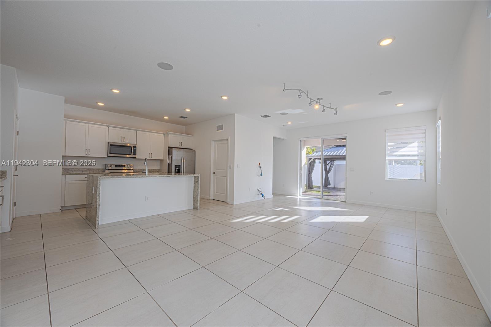 7214 Rockwood Road Jupiter, FL 33458 - Photo 14 of 28 a view of a kitchen with kitchen island white cabinets and stainless steel appliances