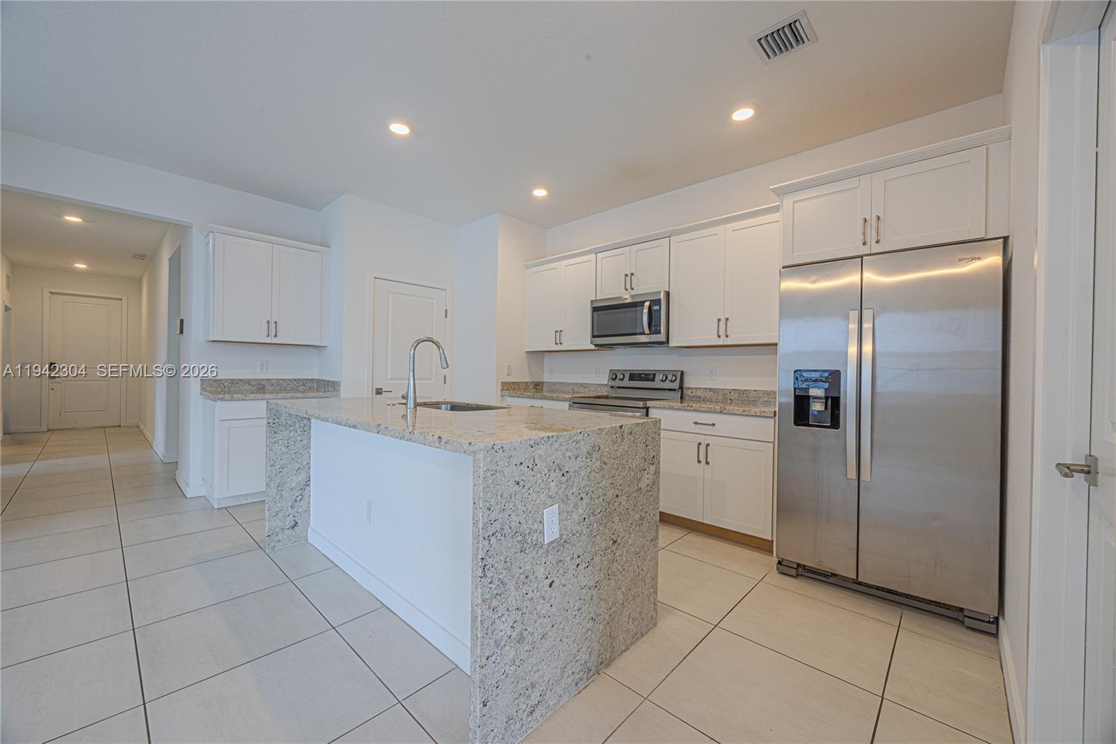 7214 Rockwood Road Jupiter, FL 33458 - Photo 17 of 28 a kitchen with cabinets and stainless steel appliances
