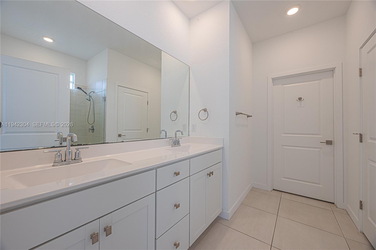 7214 Rockwood Road Jupiter, FL 33458 - Photo 22 of 28 a spacious bathroom with a double vanity sink and mirror