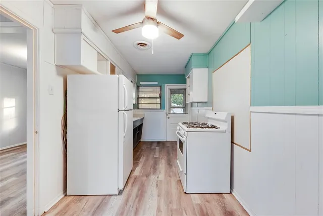 a kitchen with a refrigerator a stove top oven and a dining table