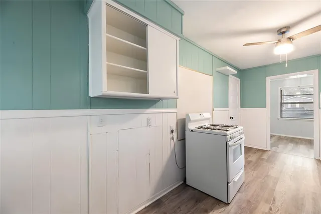 a kitchen with a stove cabinets and wooden floor