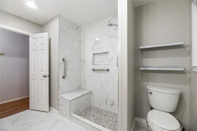 a bathroom with a toilet and a shower