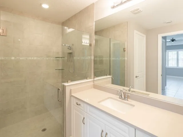 a bathroom with a granite countertop sink mirror and shower