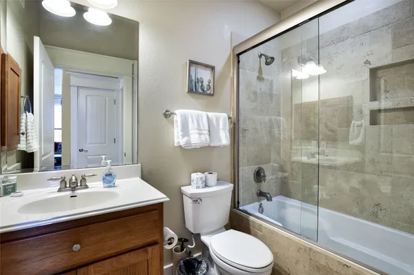 a bathroom with a sink toilet a mirror and shower