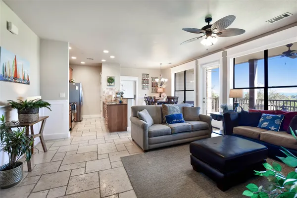 a living room with furniture kitchen view and a potted plant