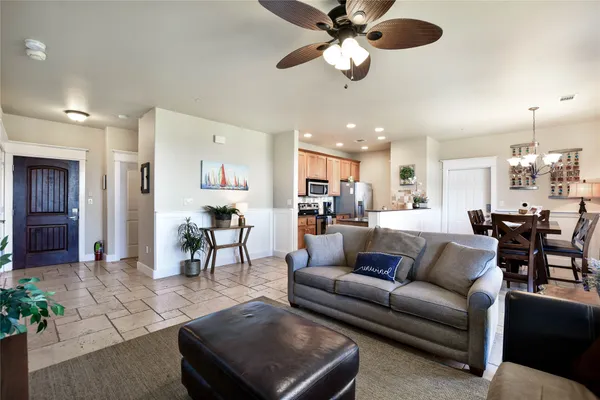 a living room with furniture kitchen view and a chandelier