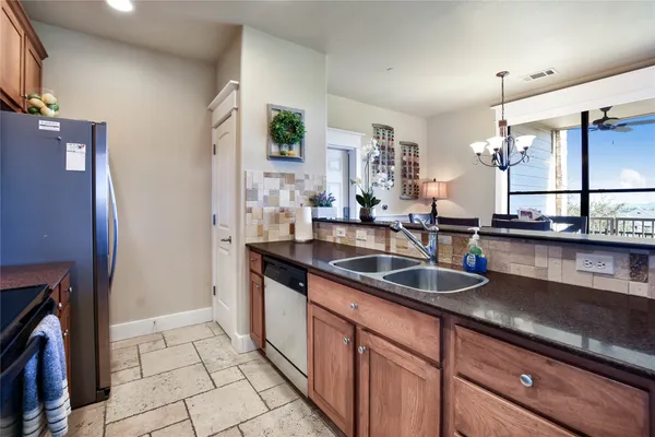 a kitchen with granite countertop a sink stove and cabinets