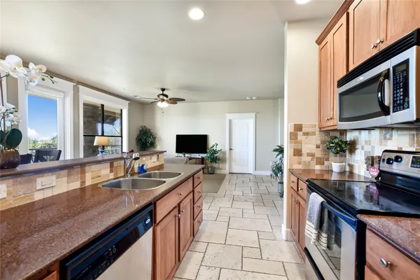 a large kitchen with kitchen island a sink stove and microwave