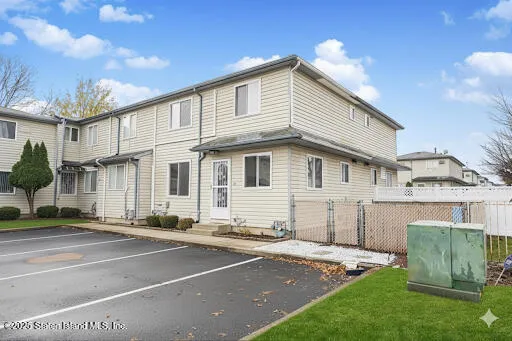 a view of an empty room with wooden floor and a kitchen