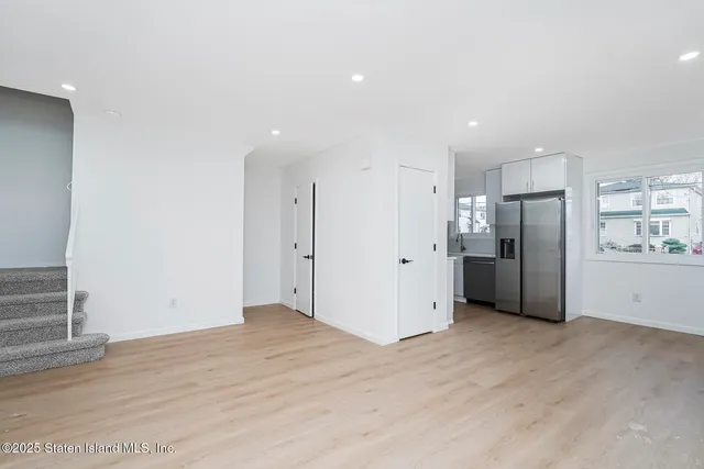 a kitchen with stainless steel appliances granite countertop a refrigerator a stove and a sink with wooden floor