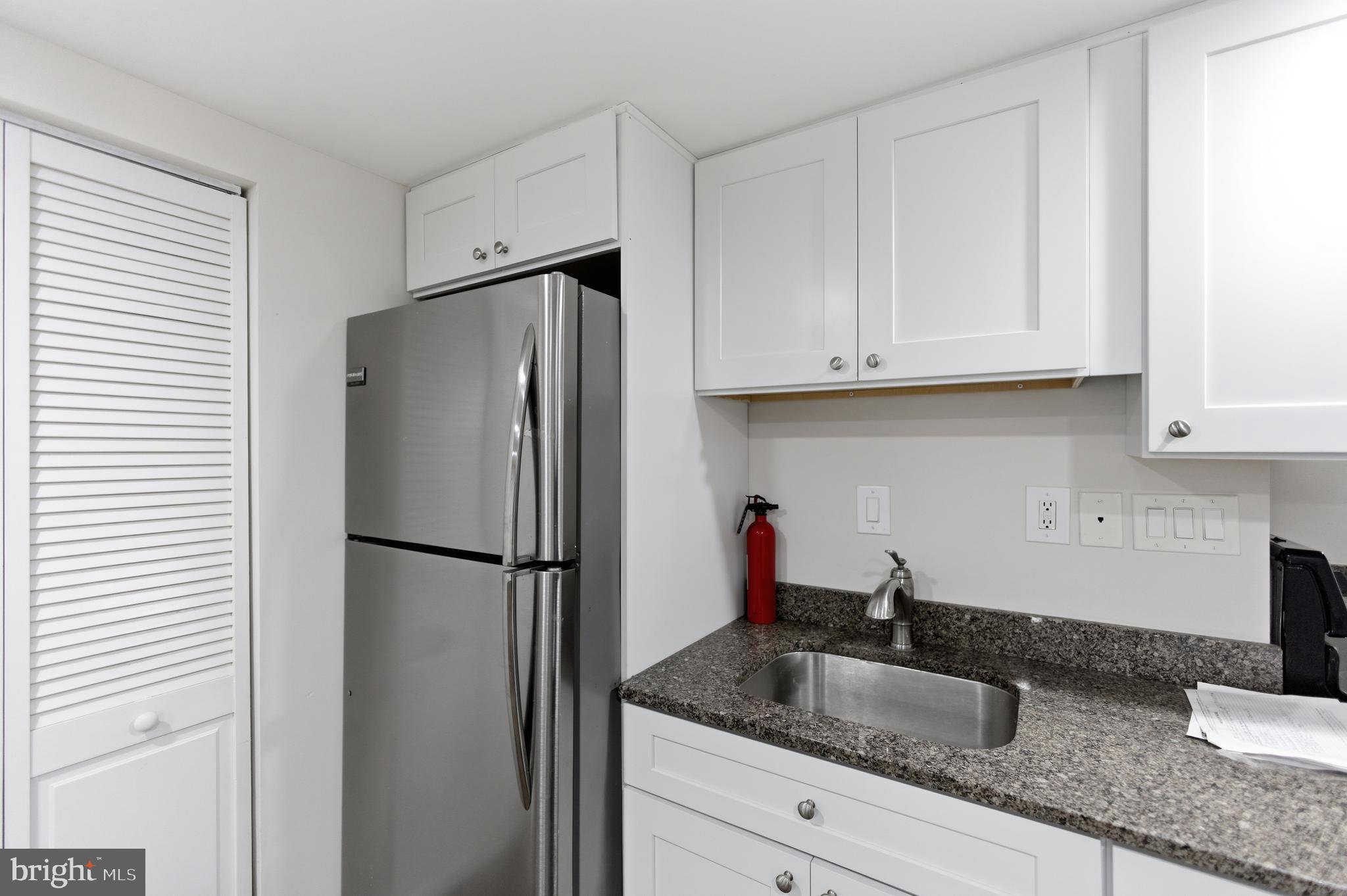 10 Girard Street Northeast Washington, DC 20002 - Photo 12 of 31 a kitchen with granite countertop a refrigerator sink and cabinets
