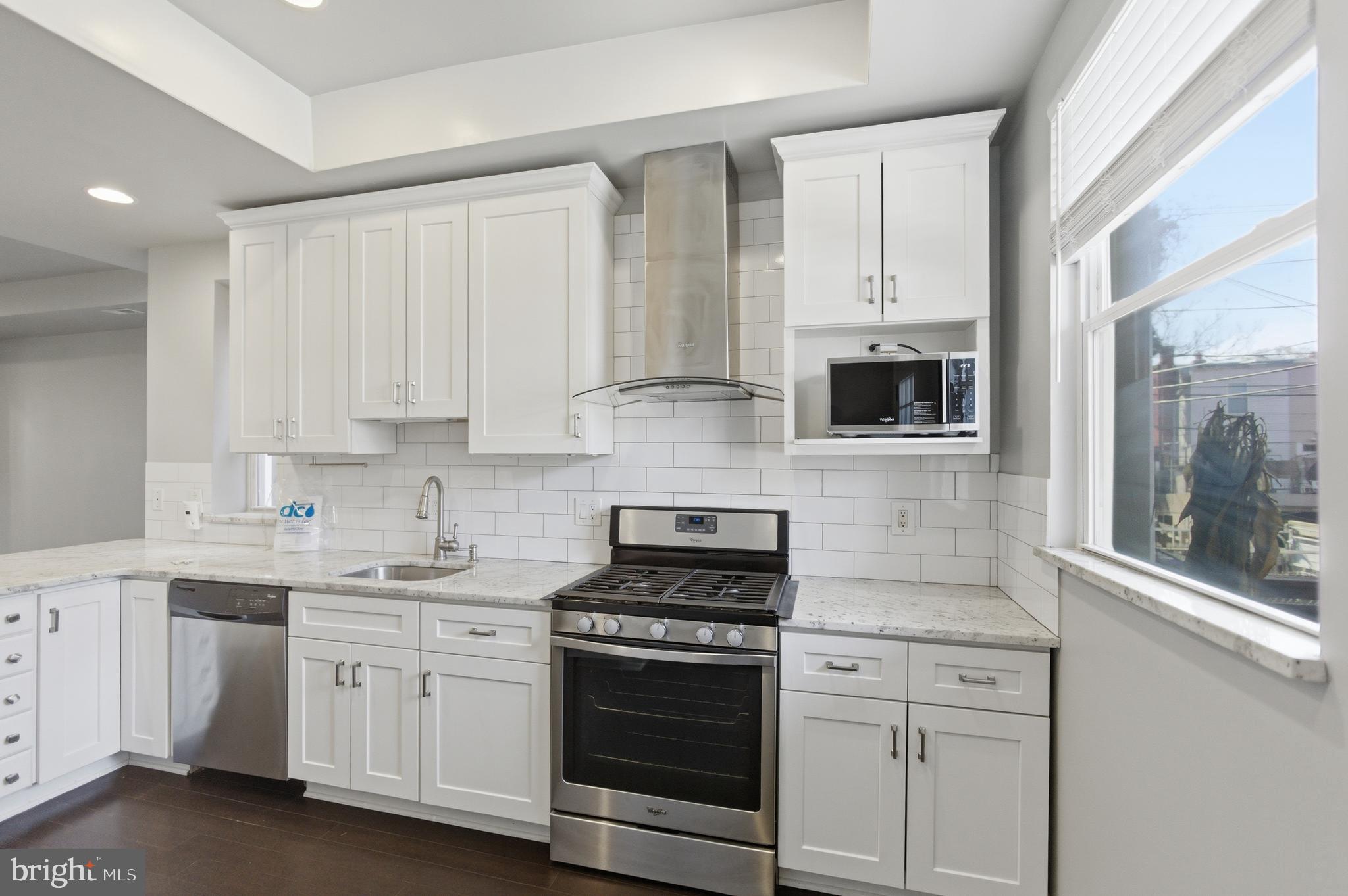 10 Girard Street Northeast Washington, DC 20002 - Photo 14 of 31 a kitchen with white cabinets and white appliances