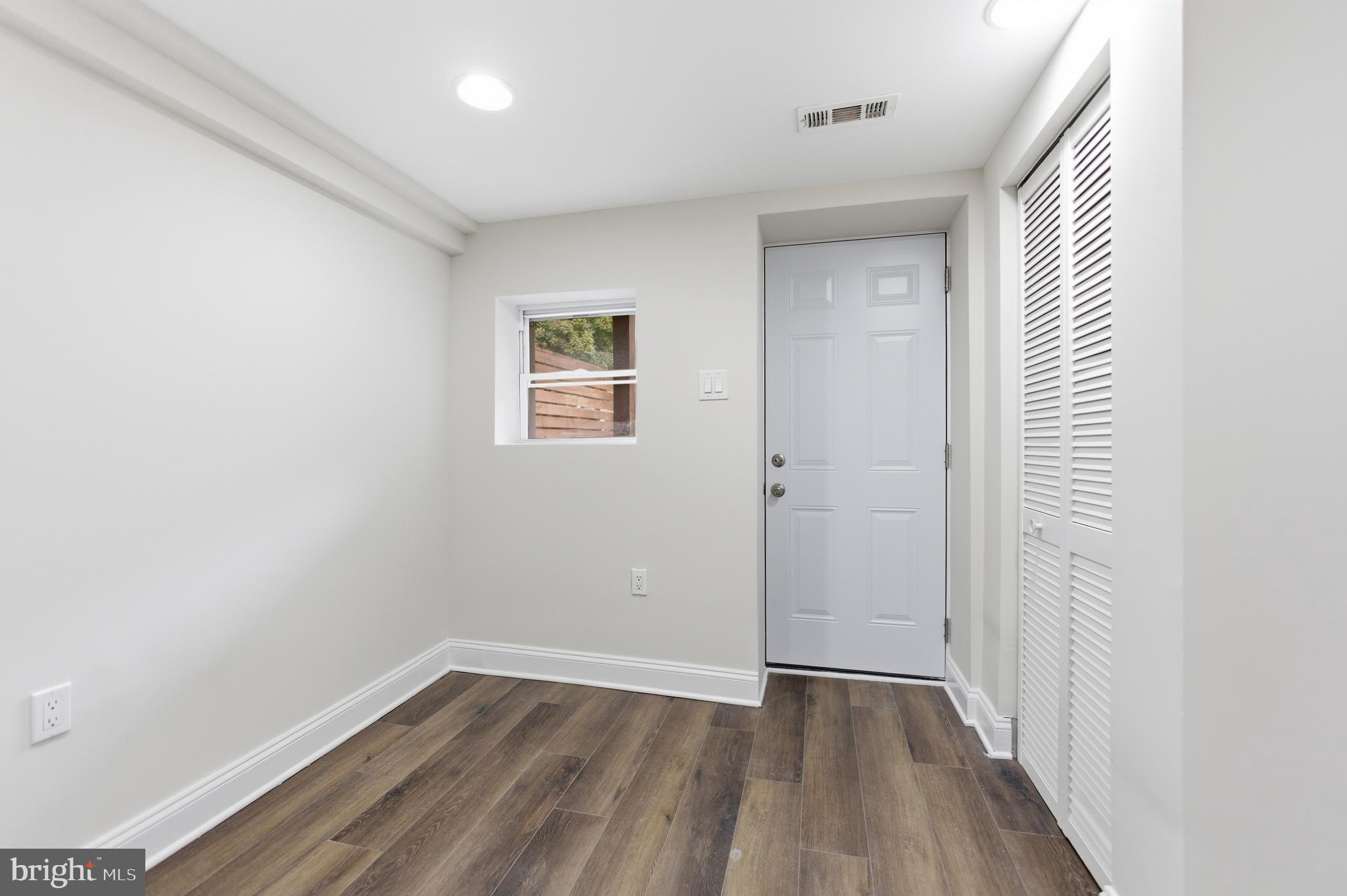 10 Girard Street Northeast Washington, DC 20002 - Photo 18 of 31 an empty room with wooden floor and windows