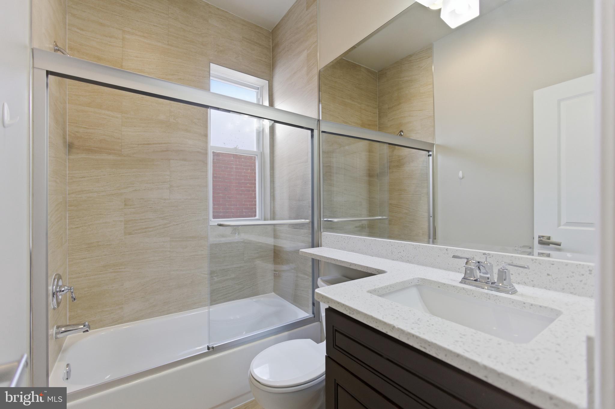 10 Girard Street Northeast Washington, DC 20002 - Photo 21 of 31 a bathroom with a granite countertop sink toilet and shower