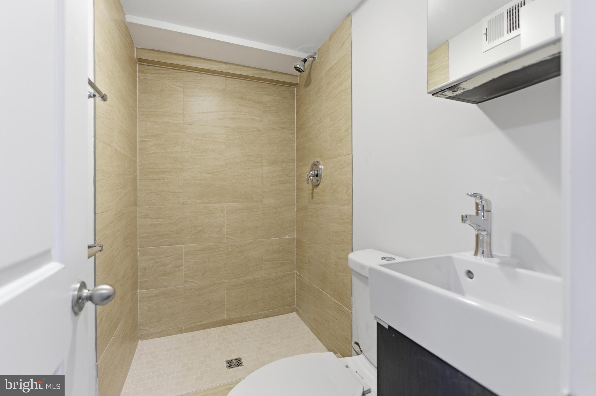 10 Girard Street Northeast Washington, DC 20002 - Photo 22 of 31 a bathroom with a bathtub shower sink vanity and toilet