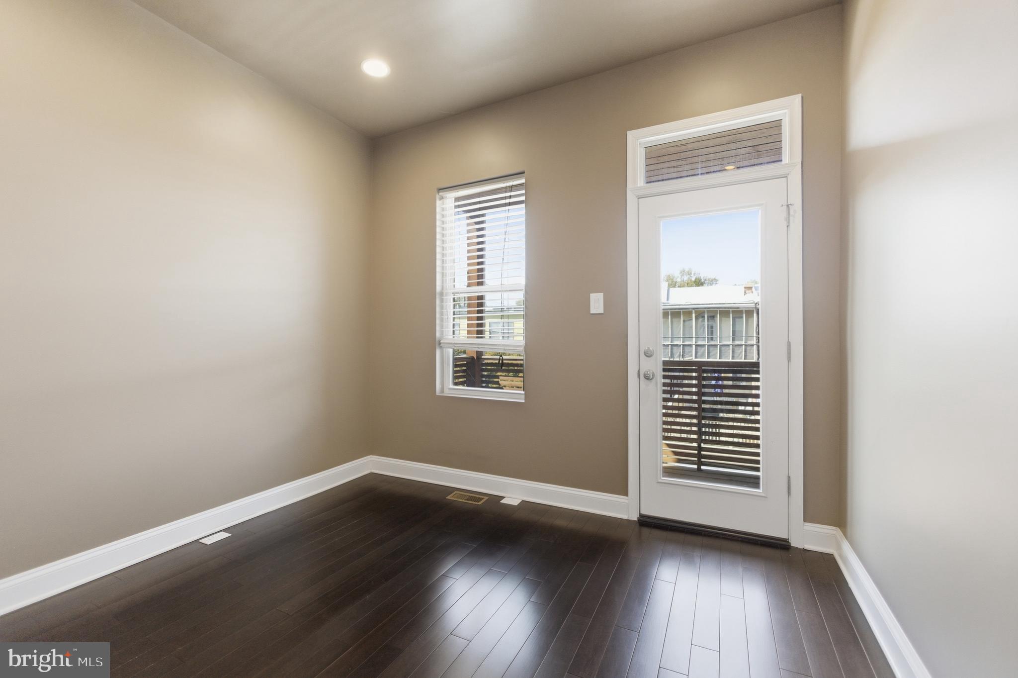 10 Girard Street Northeast Washington, DC 20002 - Photo 24 of 31 an empty room with wooden floor and windows