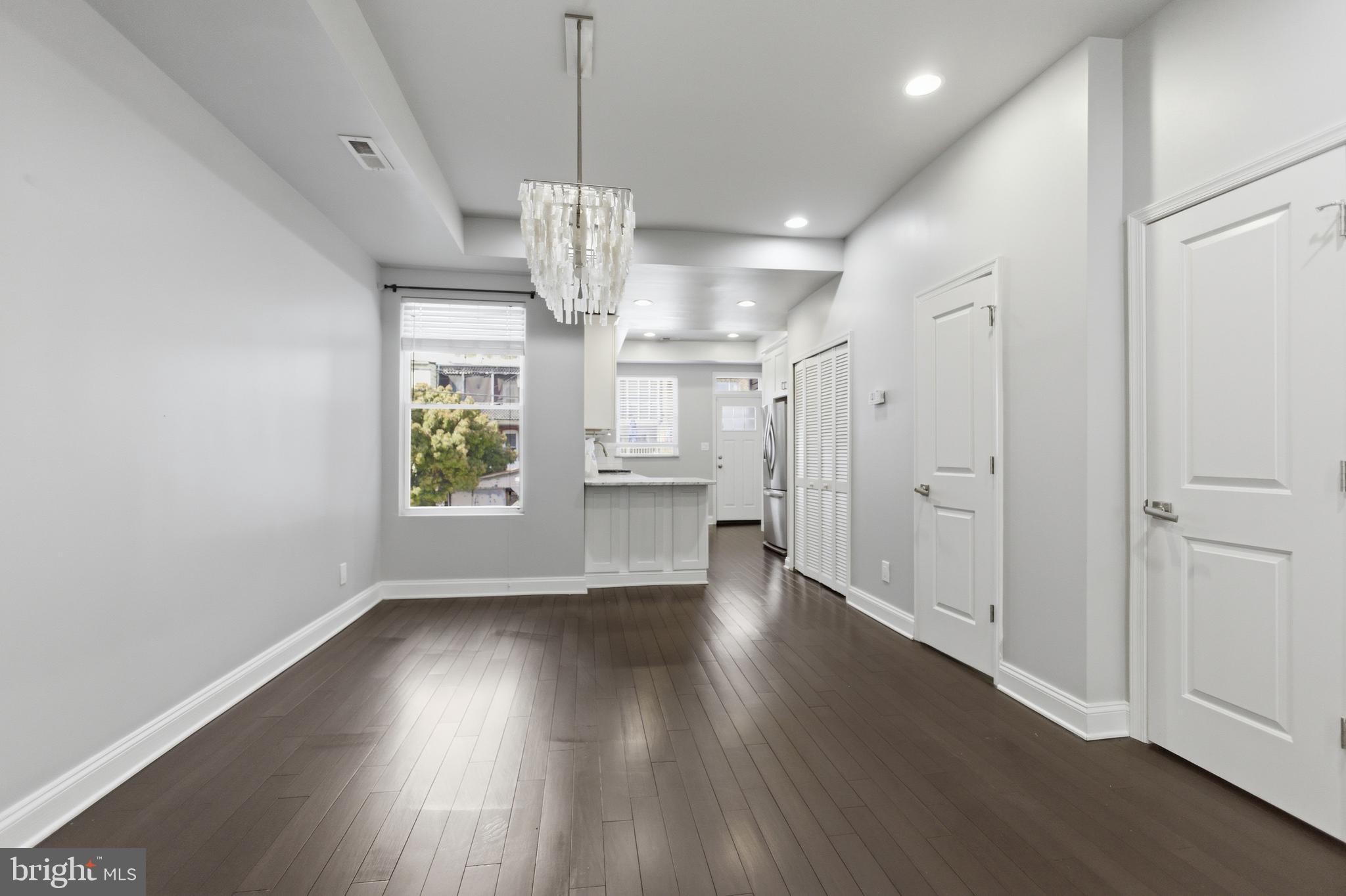 10 Girard Street Northeast Washington, DC 20002 - Photo 4 of 31 a view of an empty room with wooden floor kitchen view and a window