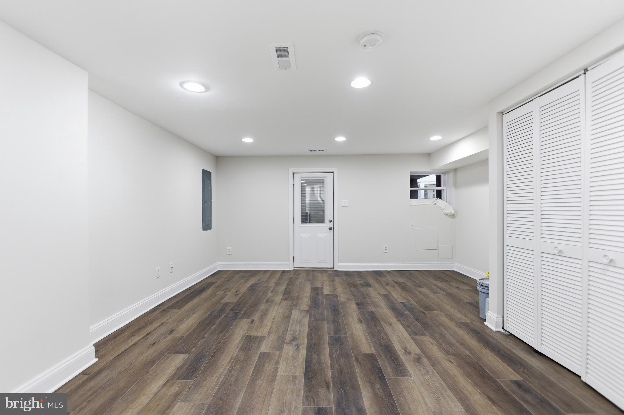10 Girard Street Northeast Washington, DC 20002 - Photo 6 of 31 an empty room with wooden floor and windows