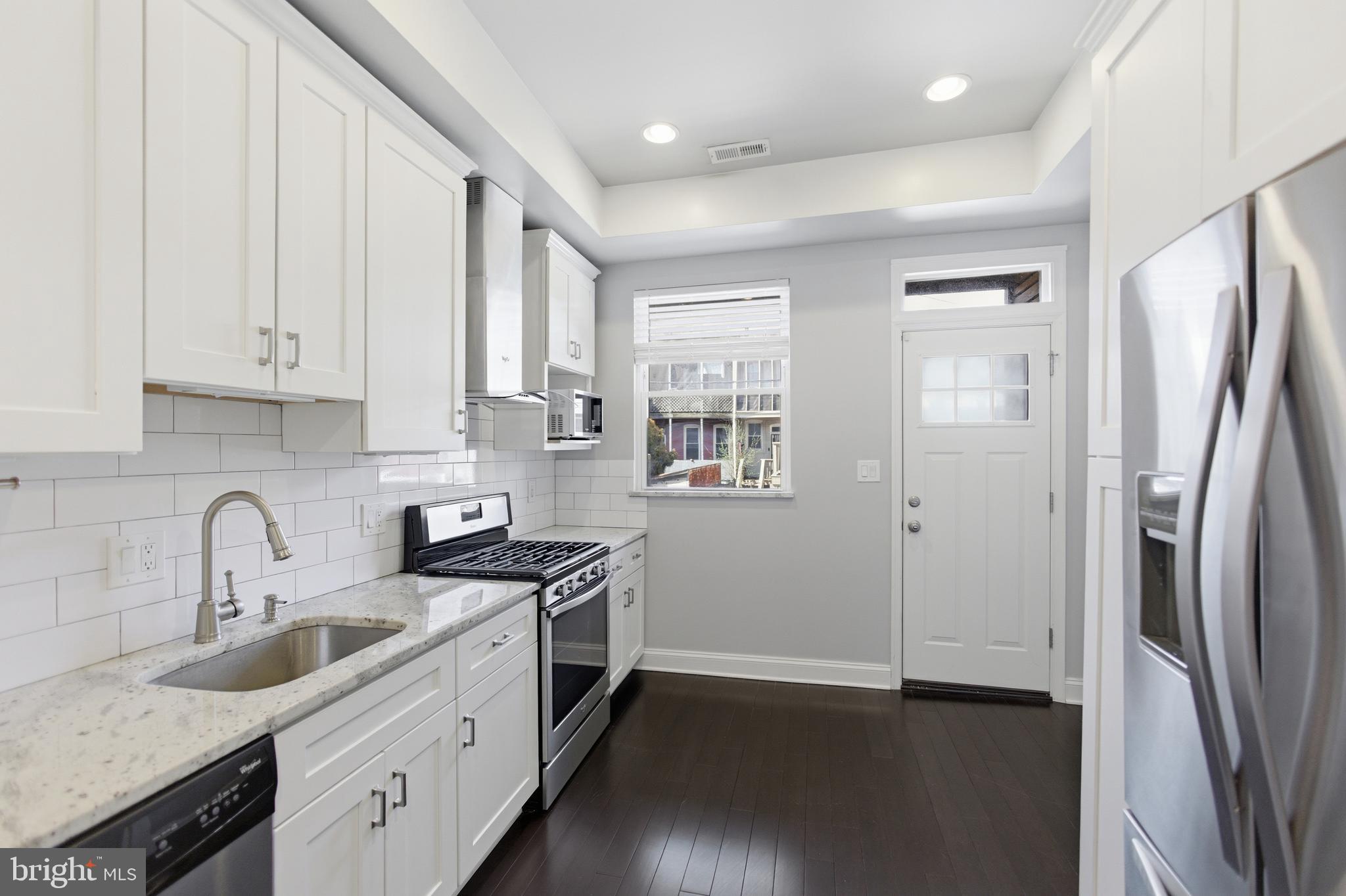 10 Girard Street Northeast Washington, DC 20002 - Photo 8 of 31 a kitchen with stainless steel appliances granite countertop a refrigerator sink and white cabinets