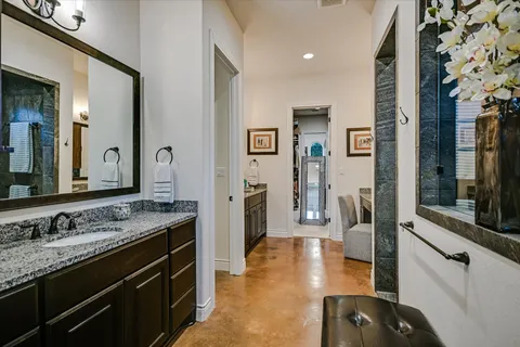 a spacious bathroom with a granite countertop sink and a mirror