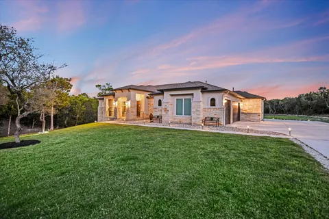a front view of a house with yard and trees