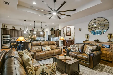 a living room with furniture a clock and a ceiling fan
