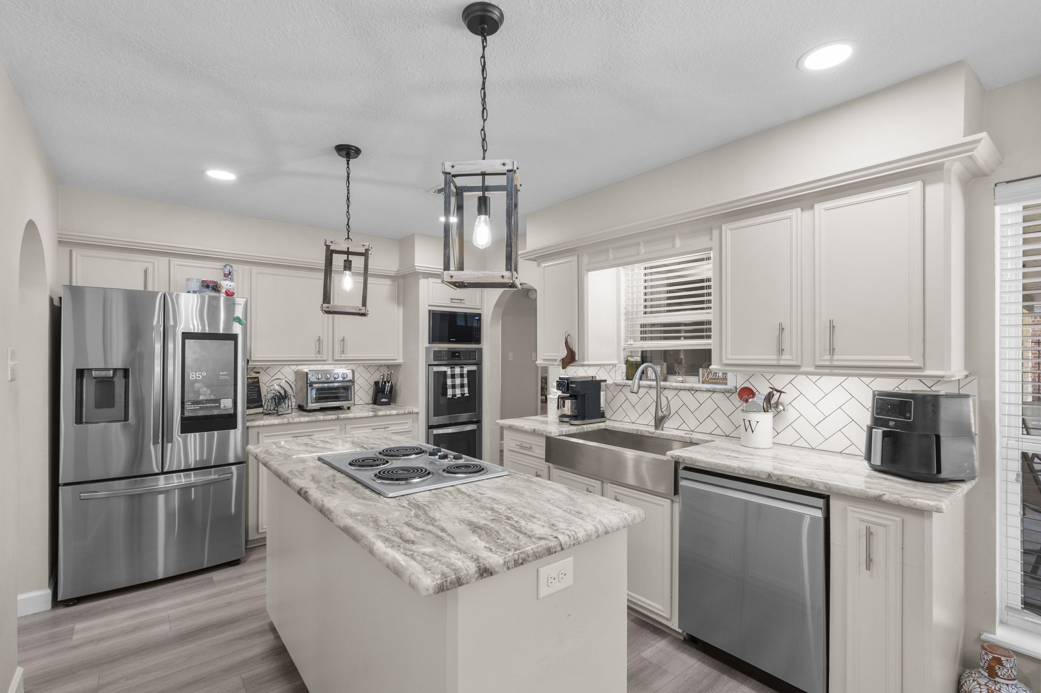 19602 Dianeshire Drive Spring, TX 77388 - Photo 16 of 37 a kitchen with stainless steel appliances kitchen island granite countertop a refrigerator a sink dishwasher a oven with white cabinets and wooden floor