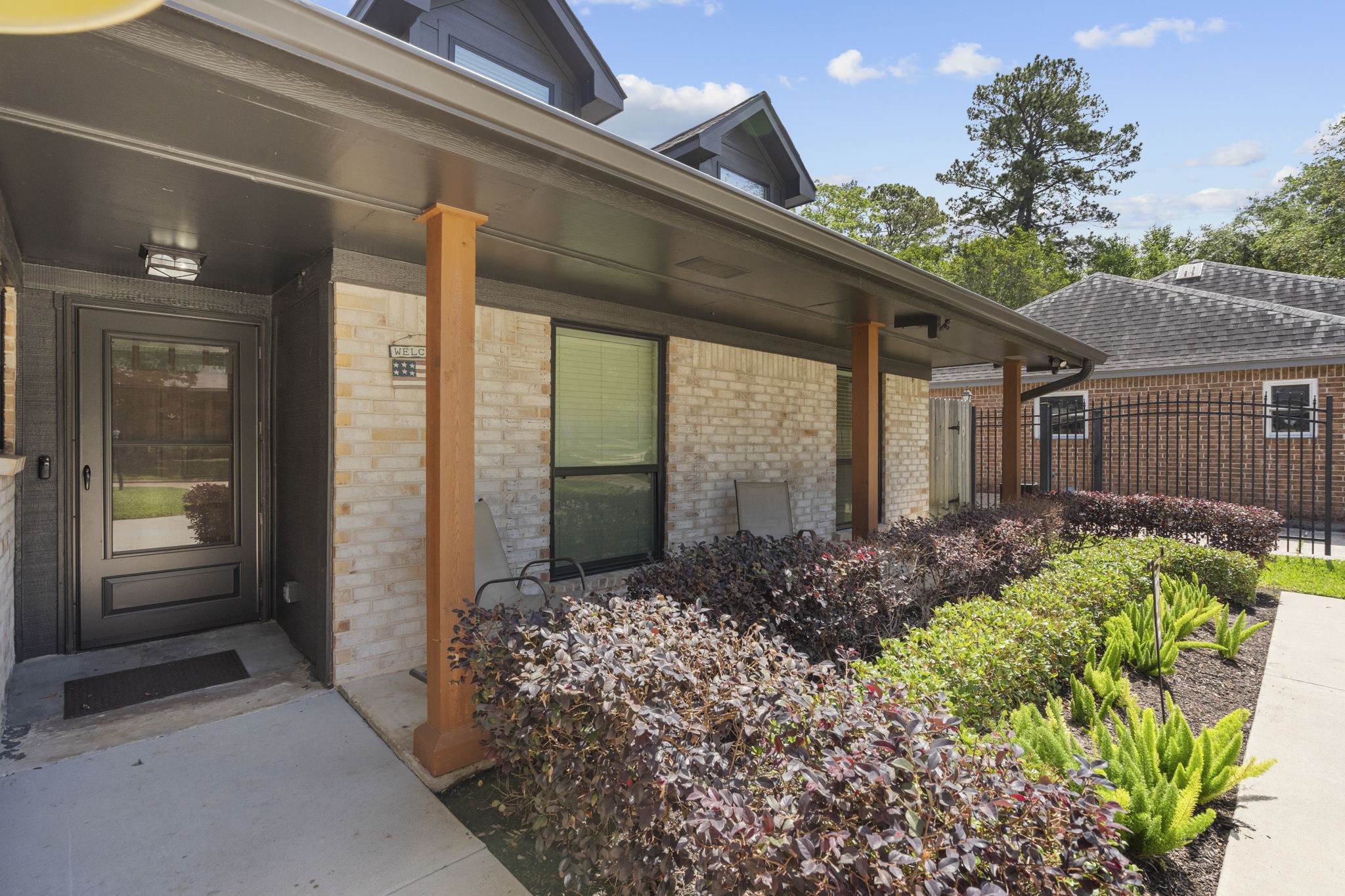 19602 Dianeshire Drive Spring, TX 77388 - Photo 6 of 37 Modern home with a covered entryway, featuring a stylish black front door and brick exterior.