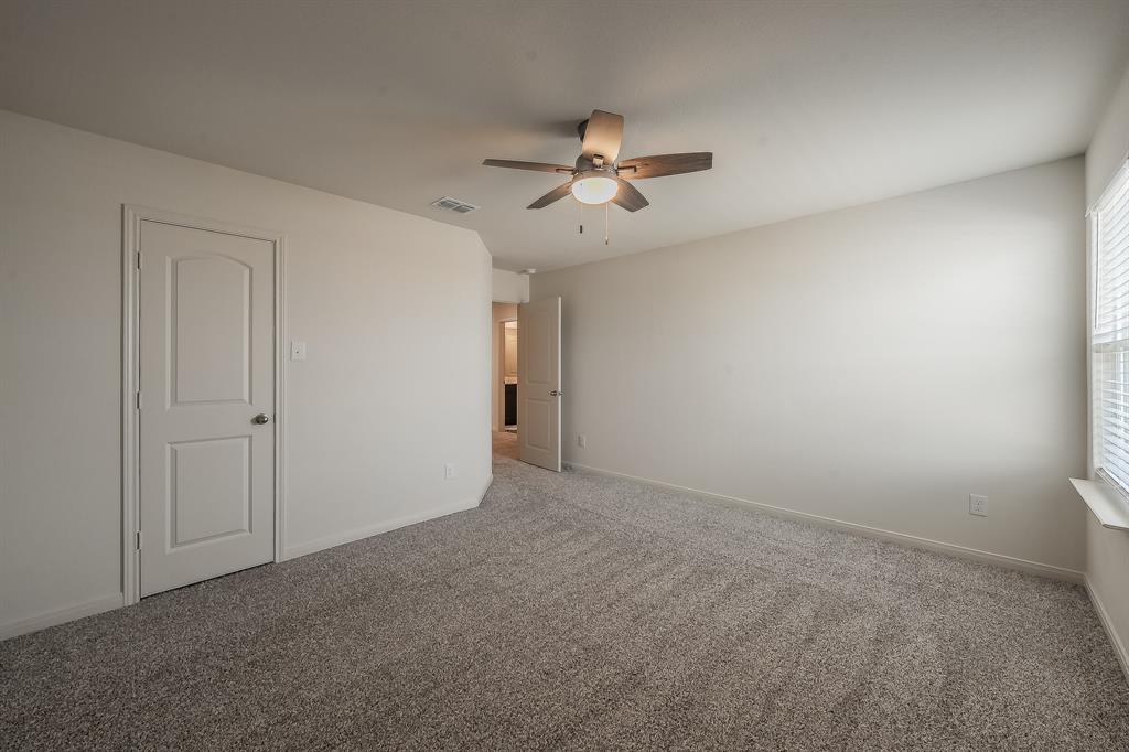 8125 White Sulphur Road Ponder, TX 76259 - Photo 22 of 38 Neutral-toned room featuring a ceiling fan with integrated lighting, textured carpeting, and a window with blinds