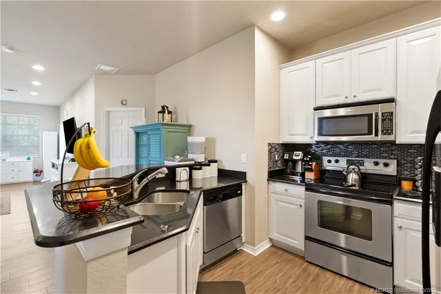 a kitchen with a sink appliances and cabinets